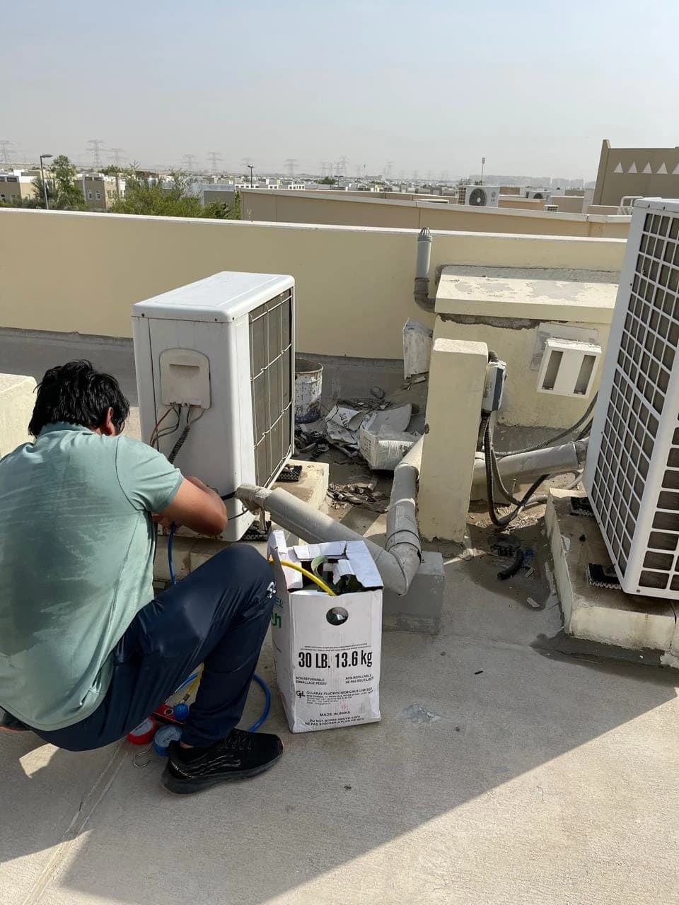 Technician installing an outdoor AC unit on a rooftop