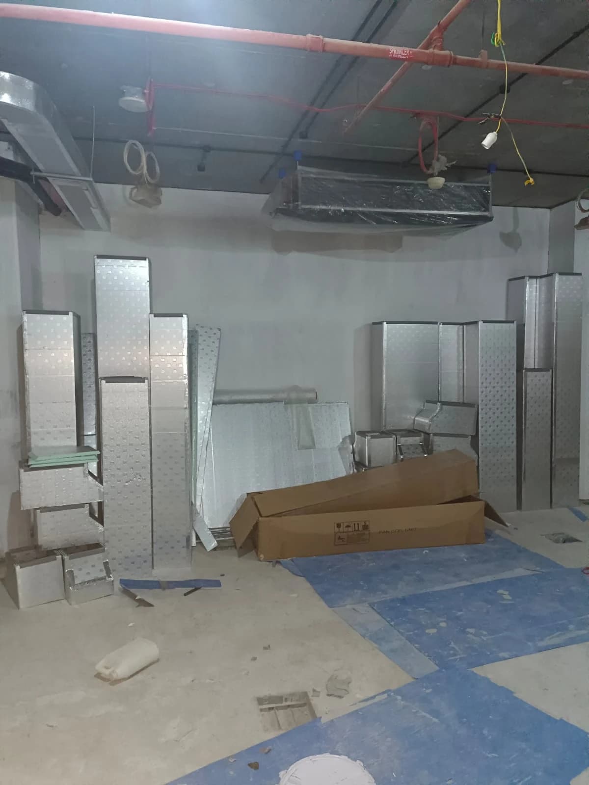 Galvanised AC ductwork sections on site during an interior fit-out