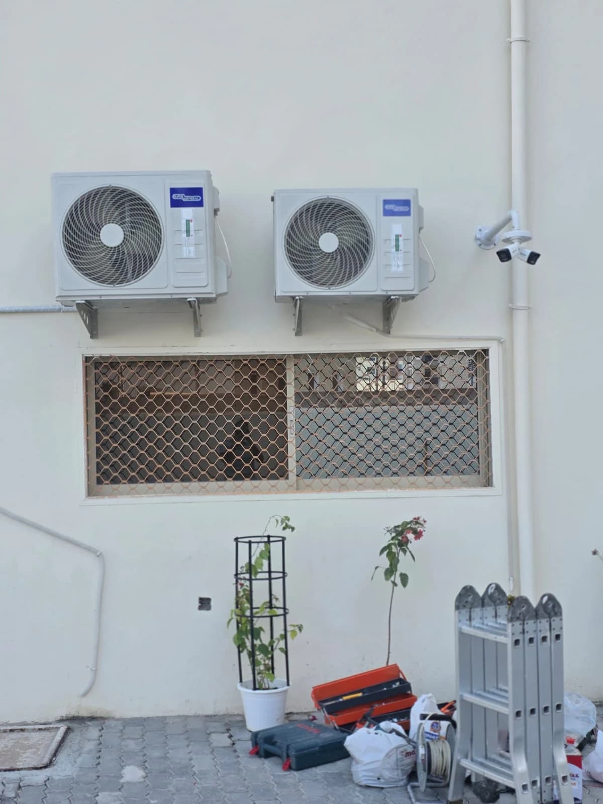 Two outdoor AC units mounted on an exterior villa wall