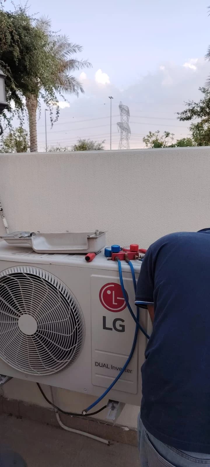 Technician connecting refrigerant pipes to an outdoor AC unit