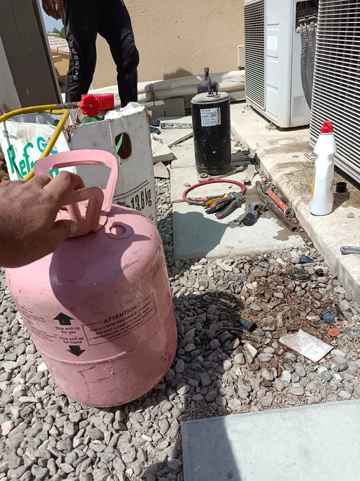 Refrigerant cylinder and compressor beside outdoor AC units on a rooftop