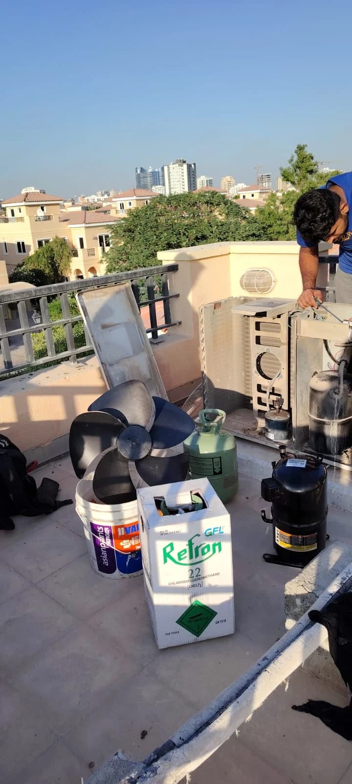 Refrigerant cylinders beside outdoor AC units on a villa rooftop