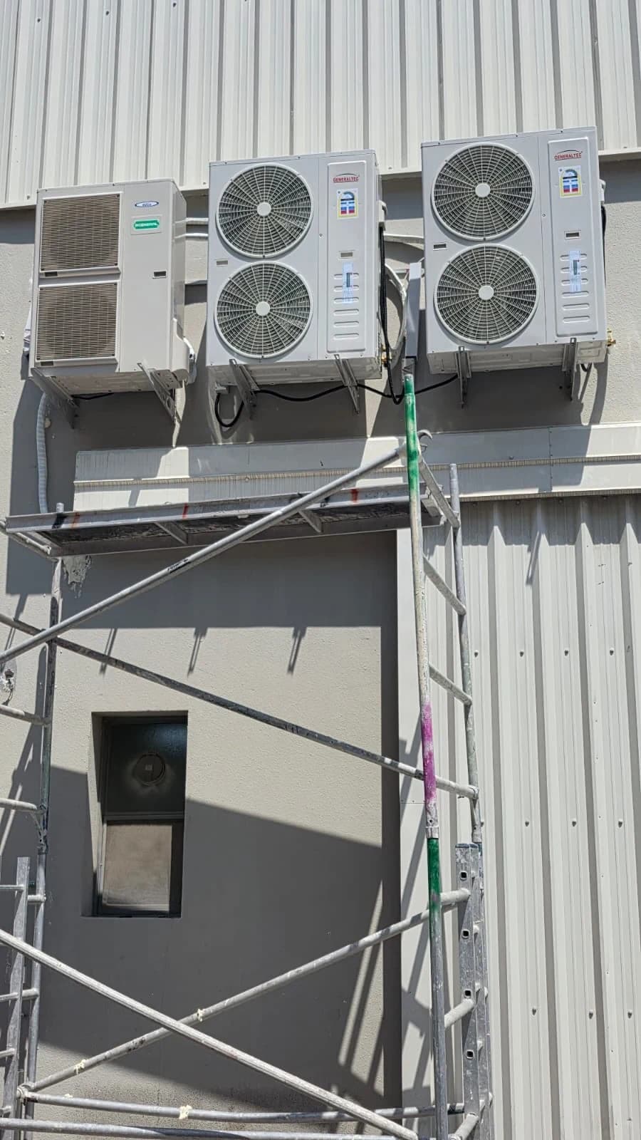 Outdoor AC units mounted high on a commercial building wall