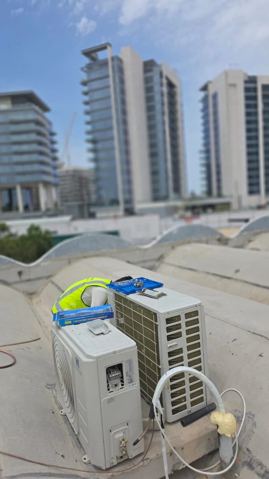 Outdoor AC units on a rooftop with towers in the background